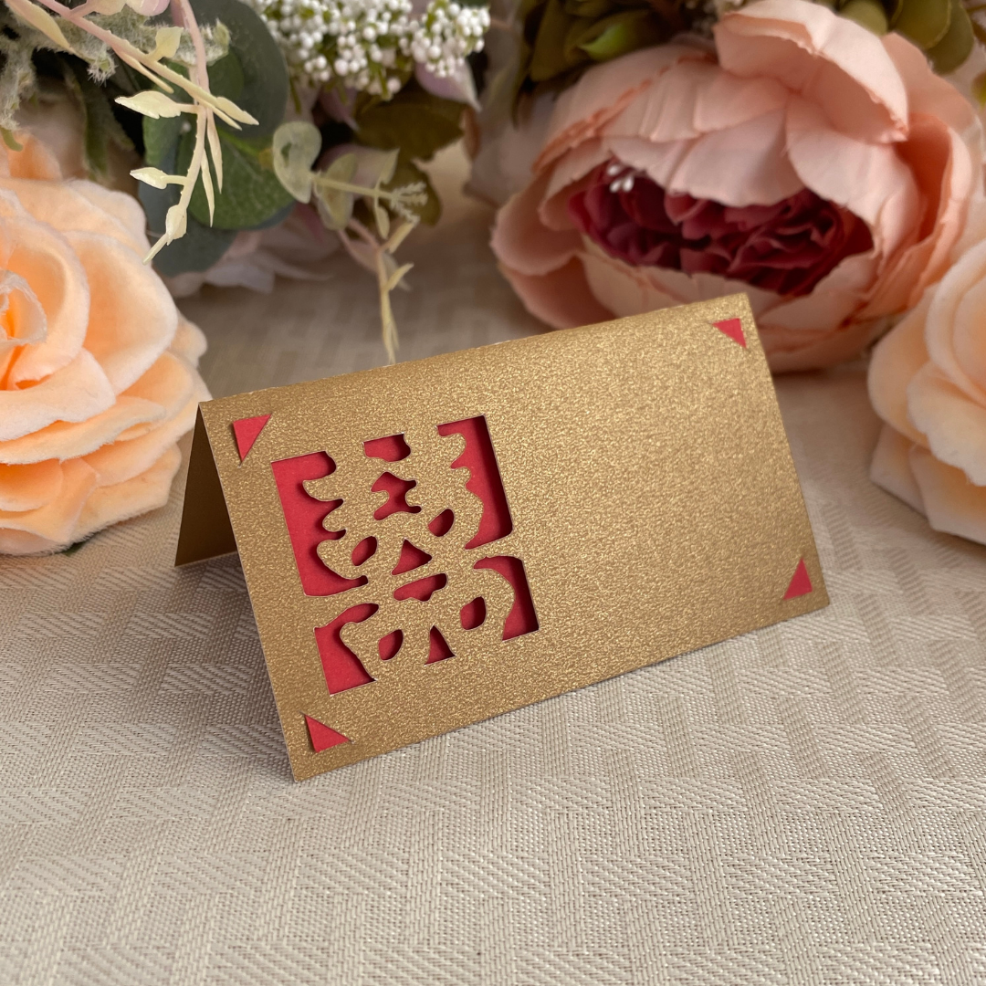 Gold double happiness folded place card with a red backing behind the symbol