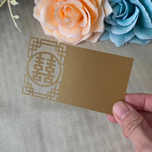 Gold Chinese wedding place card with the double happiness symbol cutout on the left side 