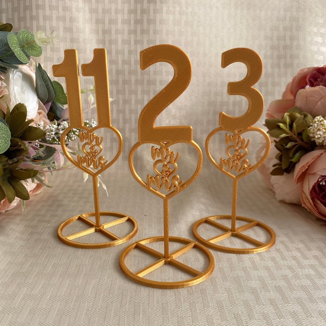 Gold table numbers with heart shaped logo with the words Mr & Mrs