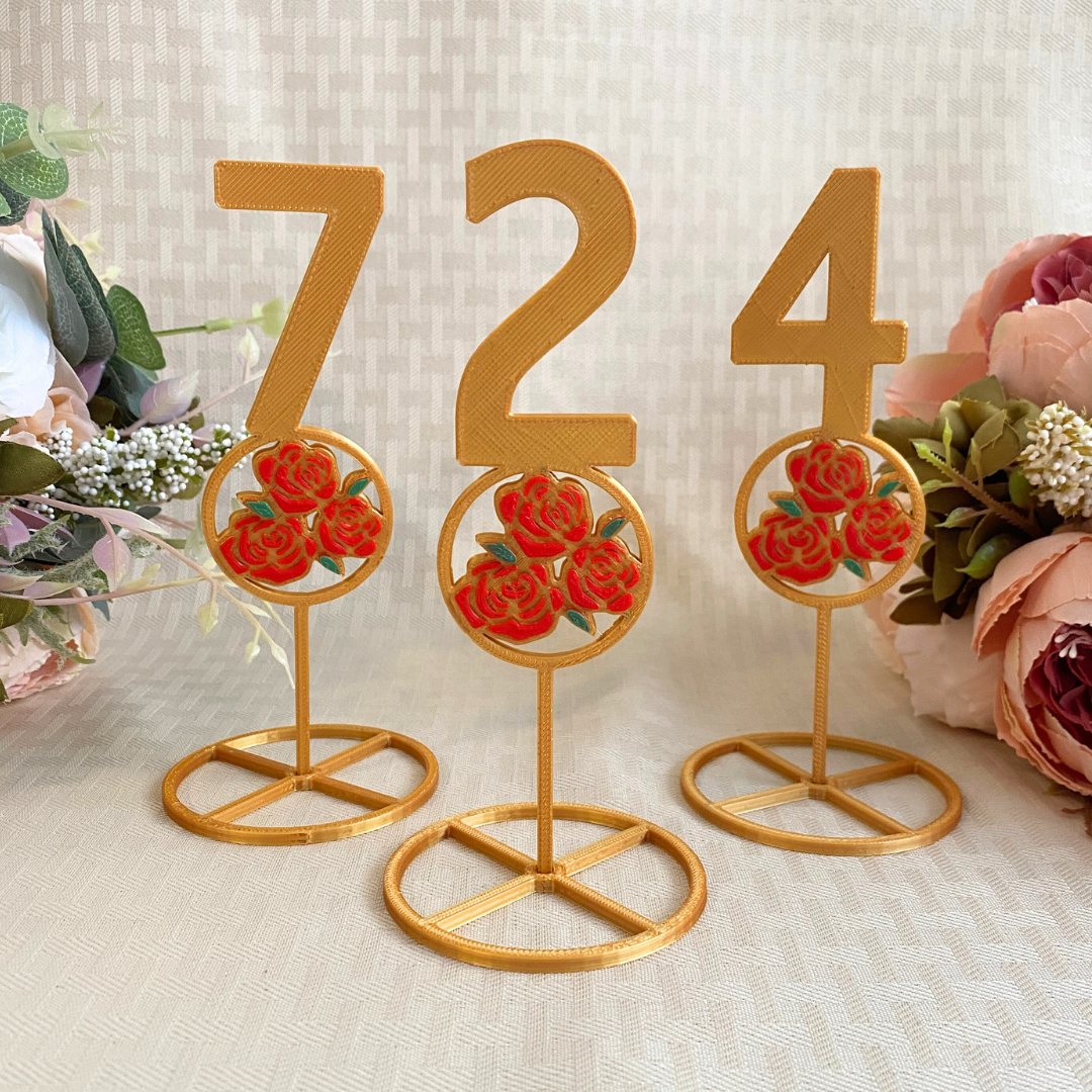 3d printed gold table numbers with red rose design for beauty and the beast wedding theme