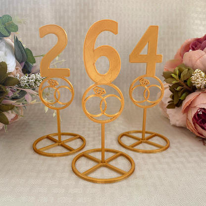 3D printed table numbers in gold showcasing wedding rings design