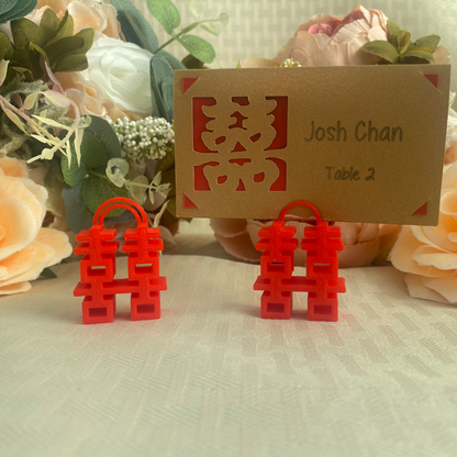 Place card holders in red made up of the double happiness symbol for Chinese weddings